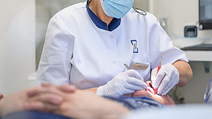 Dentiste réalisant un soin dentaire avec des loupes de précision en cabinet